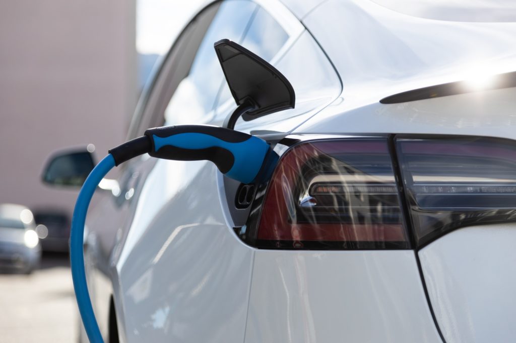 EV electric car pluged charging at a recharge station in the city